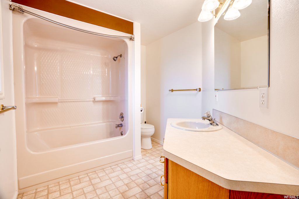 Full bathroom featuring large vanity, shower / bathtub combination, tile floors, and toilet