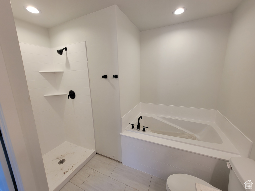 Bathroom with tile flooring, independent shower and bath, and toilet