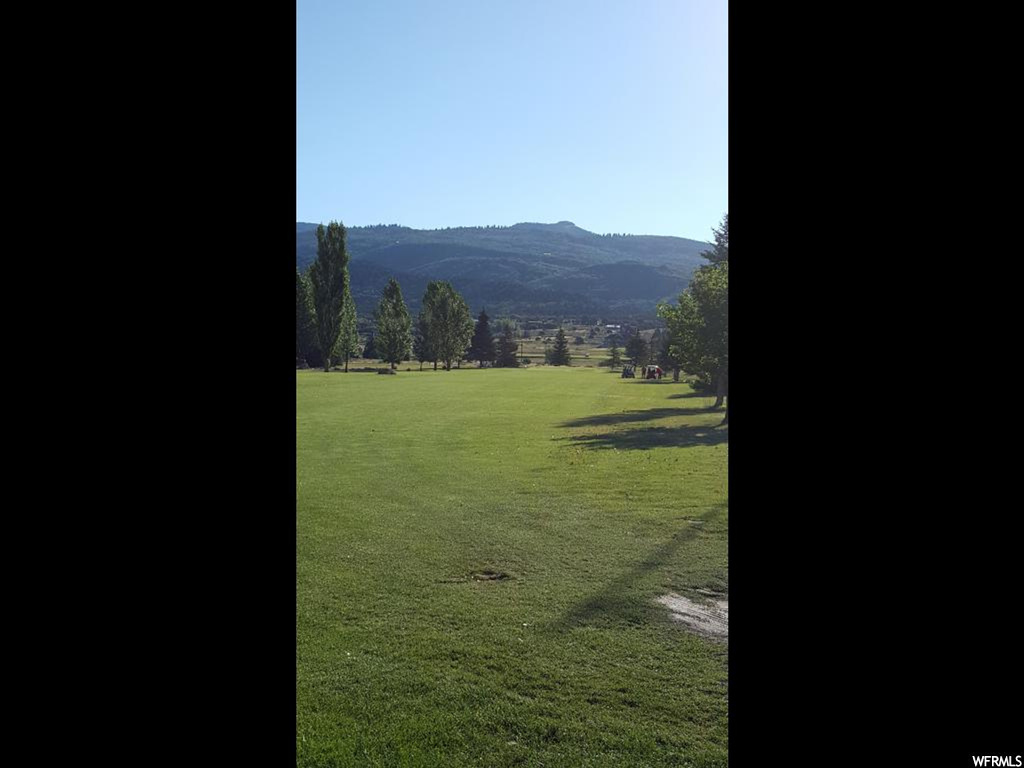 View of nearby features with a rural view, a mountain view, and a lawn