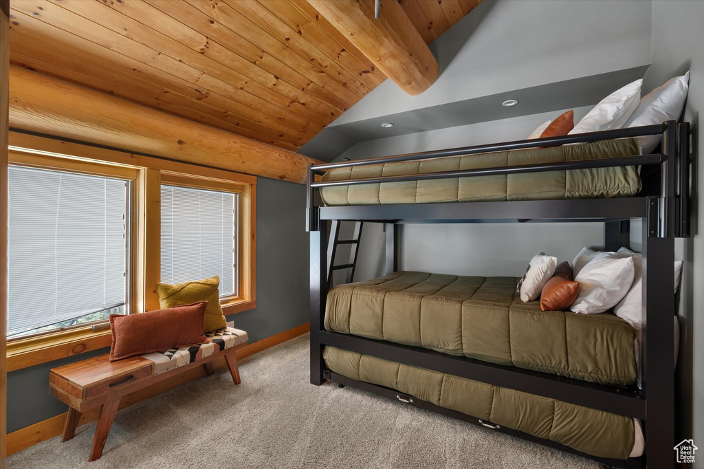 Carpeted bedroom featuring baseboards and wooden ceiling
