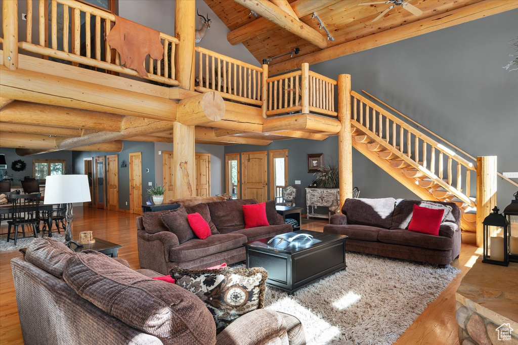Living area featuring wood finished floors, stairway, beamed ceiling, high vaulted ceiling, and wood ceiling