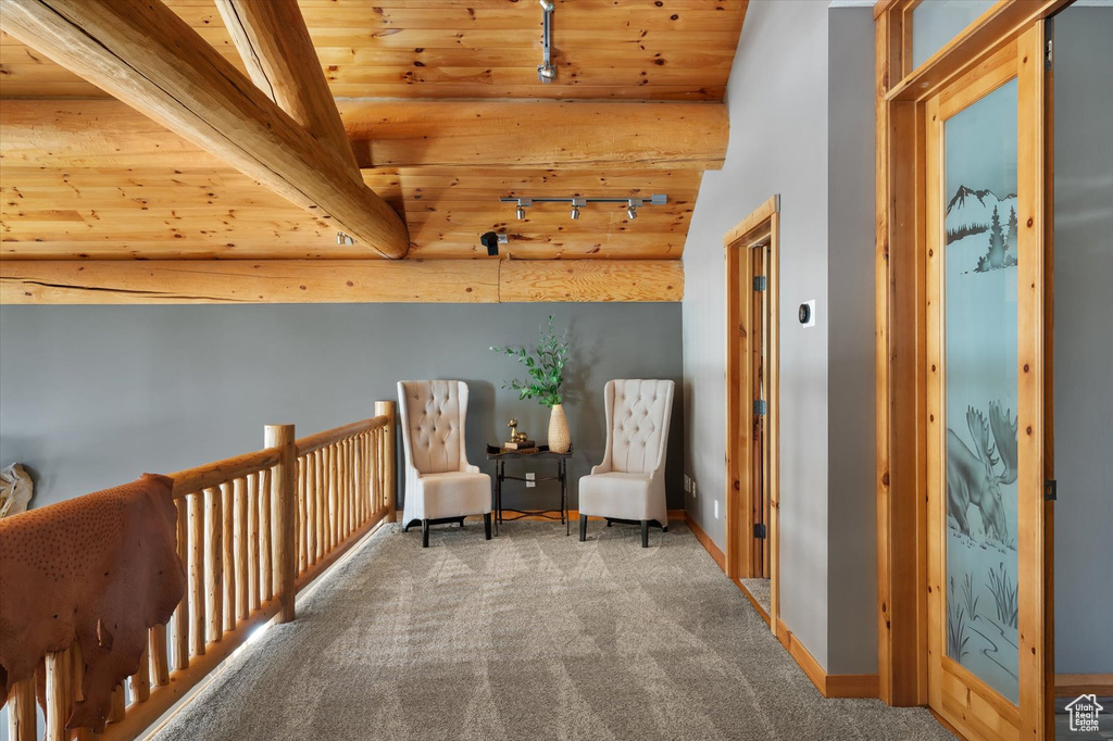 Sitting room with carpet floors, track lighting, wooden ceiling, and baseboards