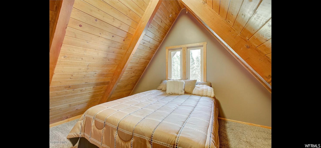 Carpeted bedroom featuring lofted ceiling, wood walls, and wooden ceiling