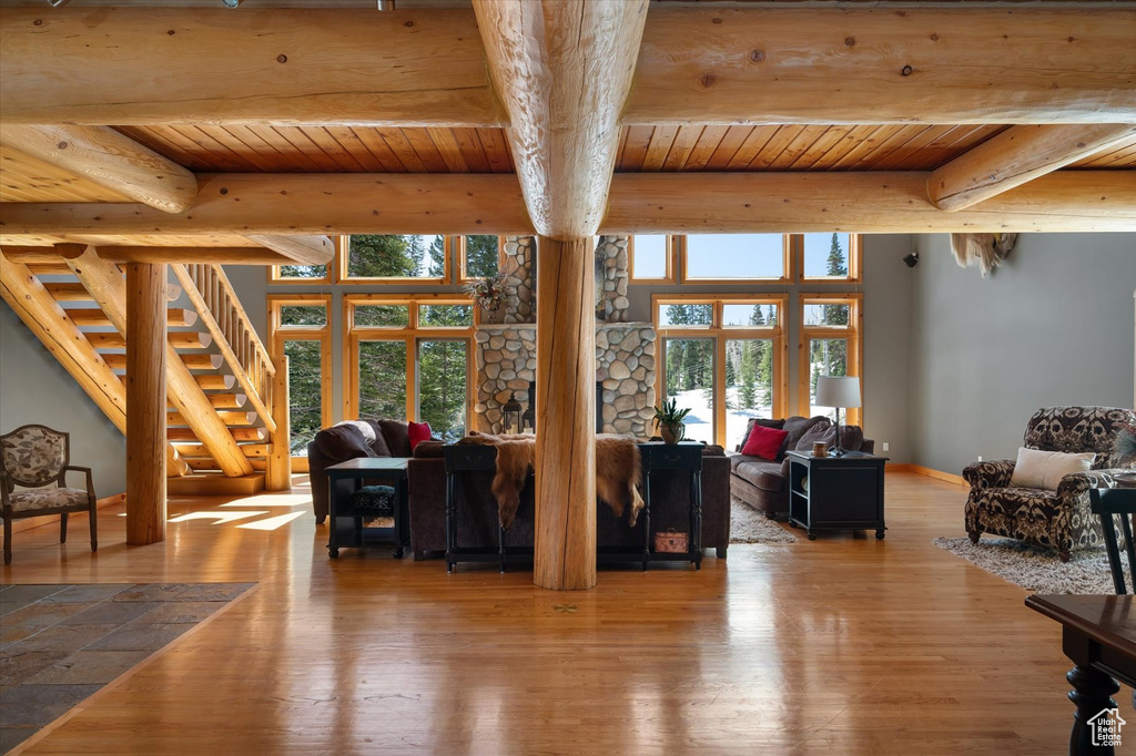 Living area with wooden ceiling, hardwood / wood-style flooring, plenty of natural light, beamed ceiling, and stairway