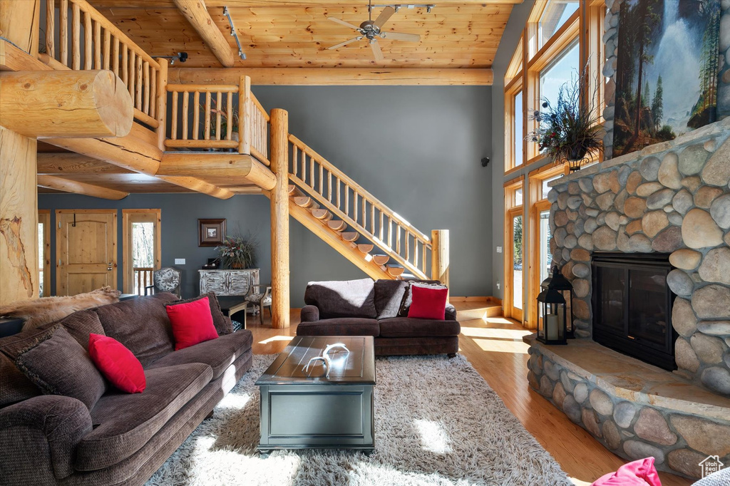 Living area with wood finished floors, stairs, a fireplace, wooden ceiling, and ceiling fan