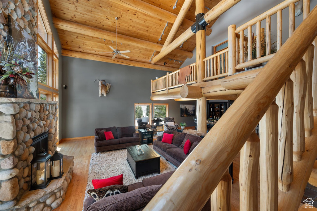 Living room with high vaulted ceiling, wooden ceiling, a ceiling fan, beamed ceiling, and wood finished floors