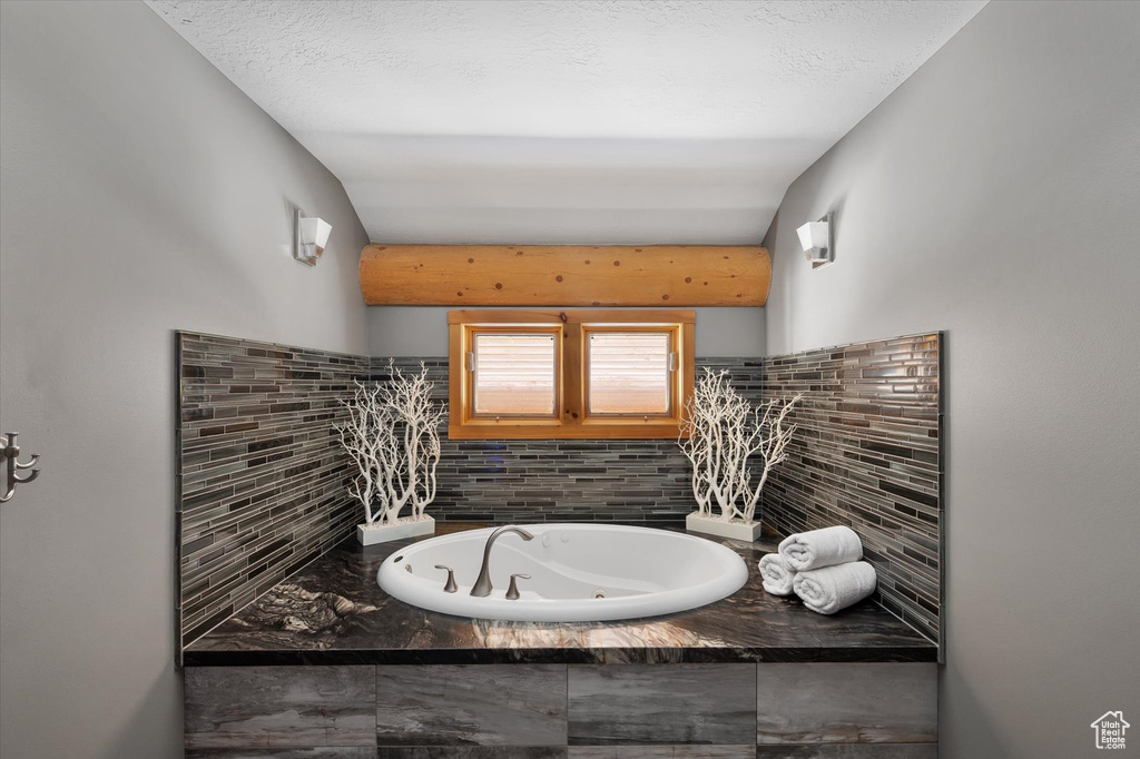 Bathroom with a whirlpool tub and backsplash