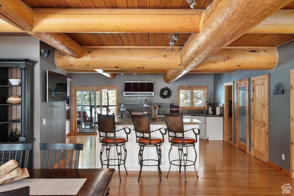 Dining area featuring wood ceiling, wood finished floors, beam ceiling, and plenty of natural light