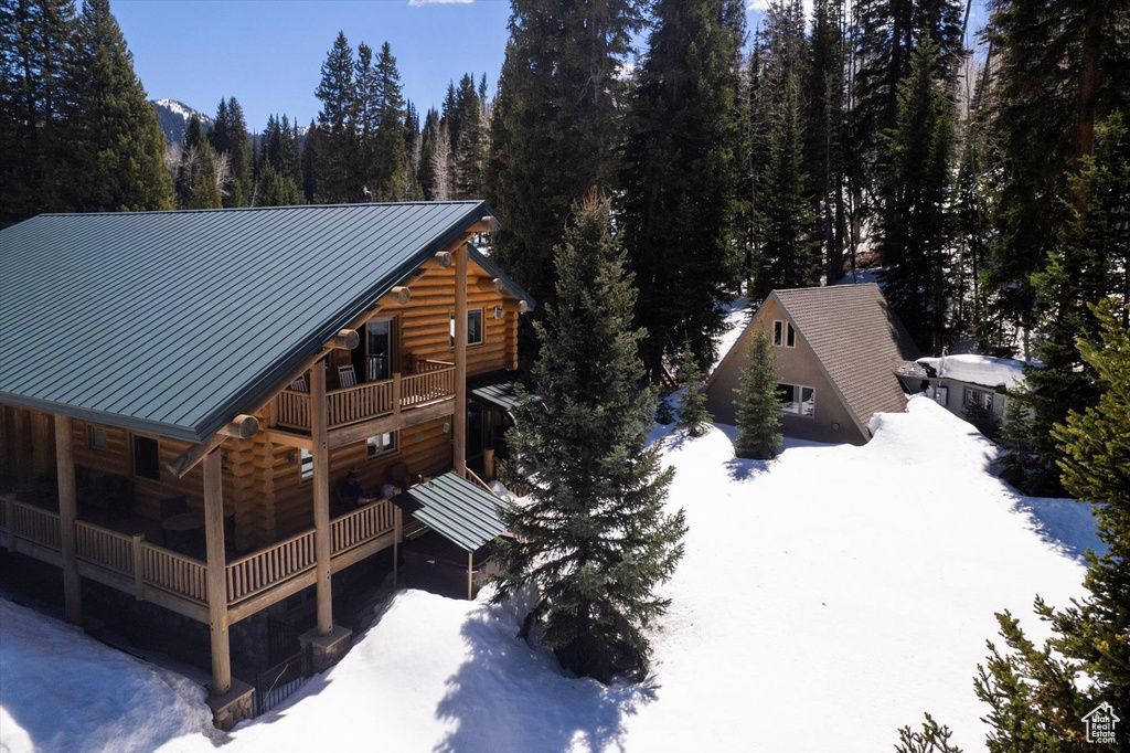 Snowy aerial view featuring a wooded view