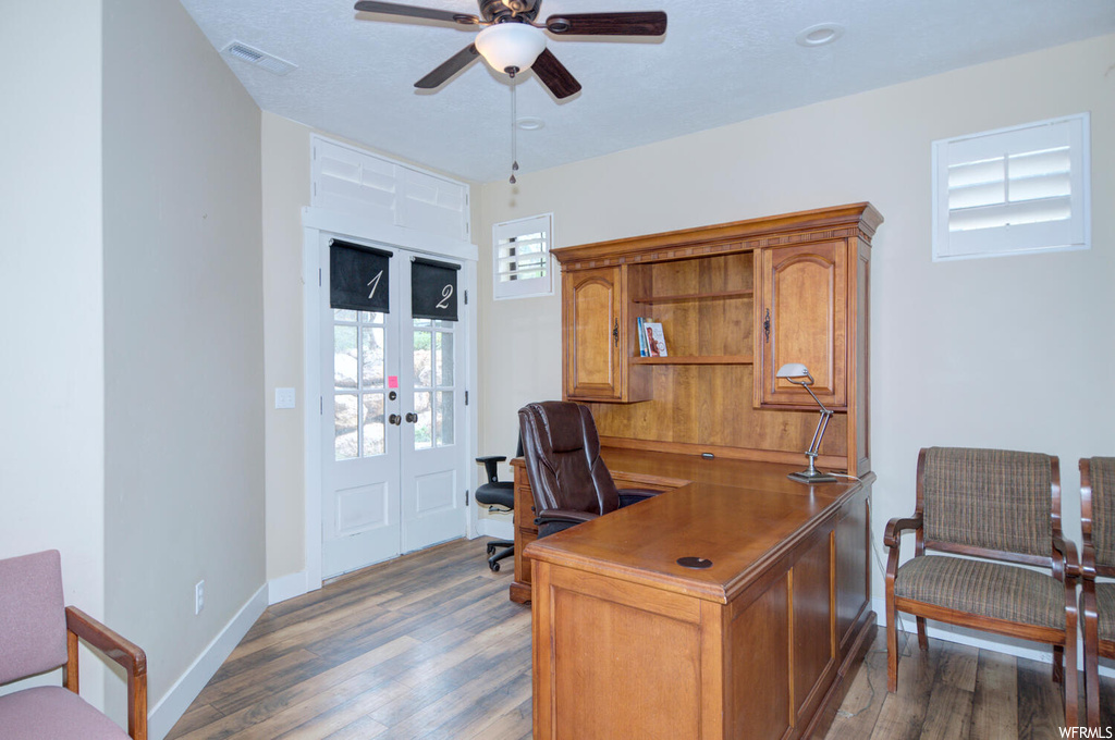 Hardwood floored home office featuring ceiling fan and french doors