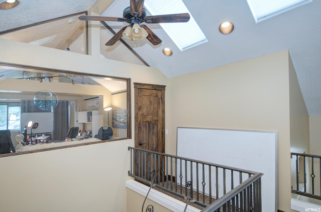 Hall featuring a skylight and vaulted ceiling high