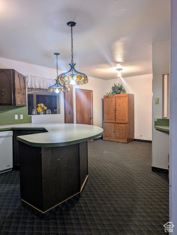 Kitchen with dark colored carpet, hanging light fixtures, dishwasher, and light countertops