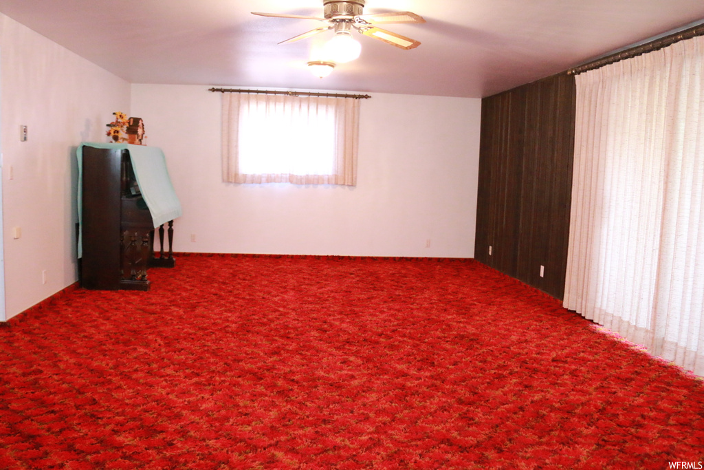 Carpeted empty room with ceiling fan