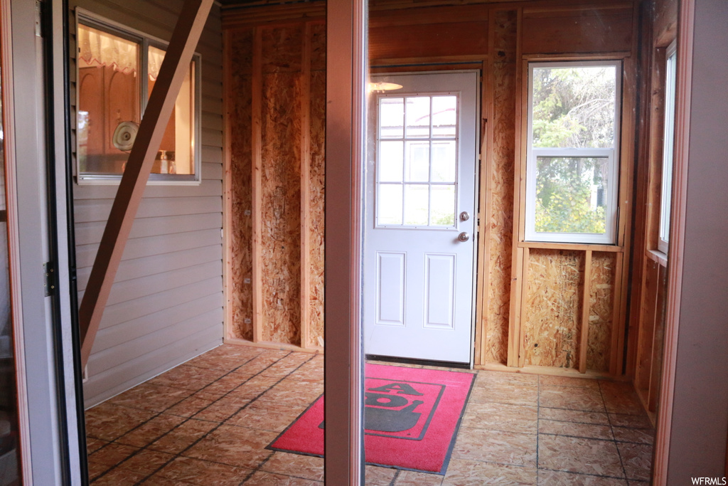 Doorway to outside with dark tile floors