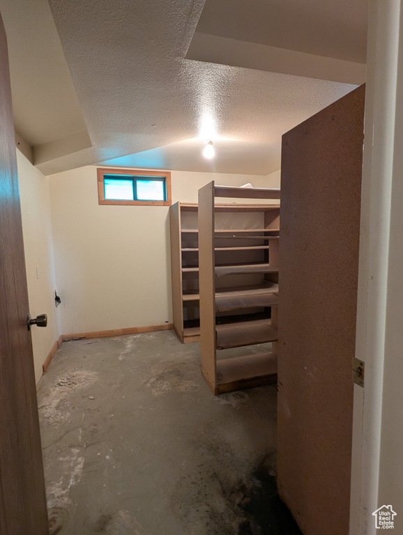 Basement with baseboards and a textured ceiling