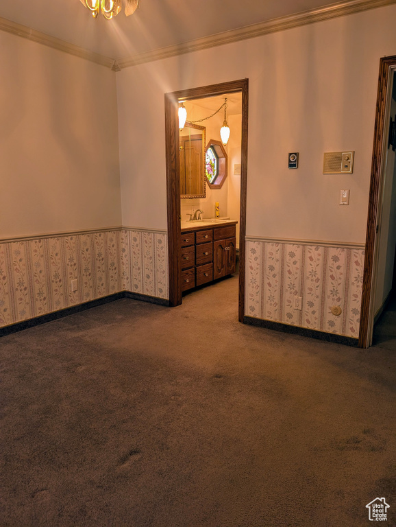 Unfurnished room featuring ornamental molding, wallpapered walls, wainscoting, and carpet floors