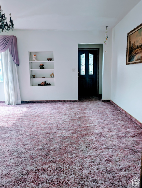 Foyer with baseboards and carpet floors
