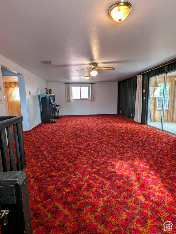 Interior space with a wood stove, ceiling fan, and visible vents