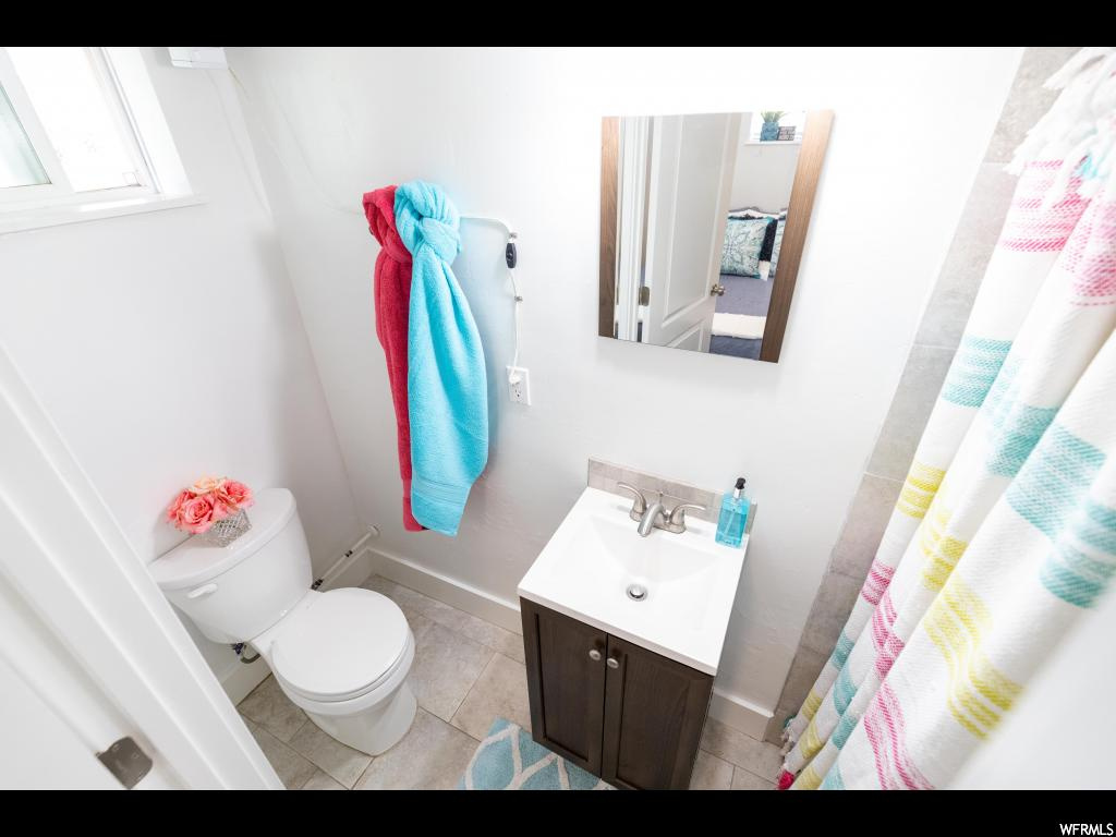 Bathroom featuring tile floors, toilet, and vanity with extensive cabinet space