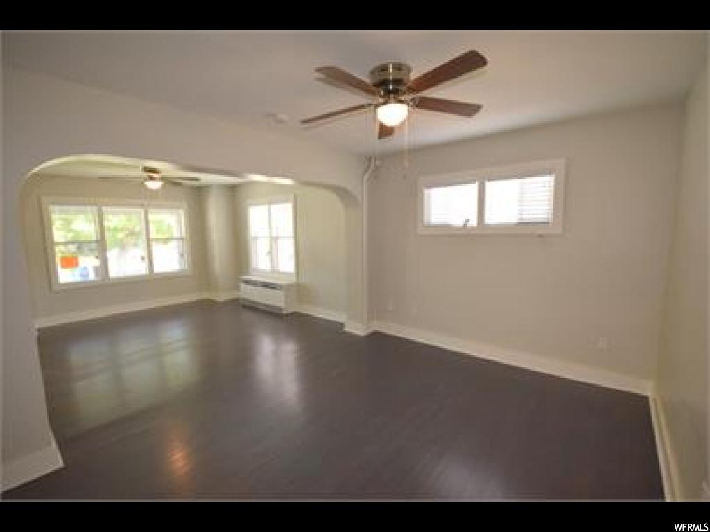 Spare room with dark hardwood floors and ceiling fan