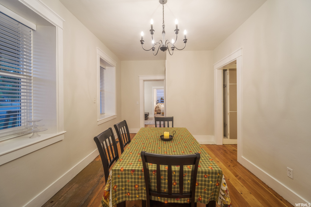 Dining area with dark hardwood floors and a notable chandelier