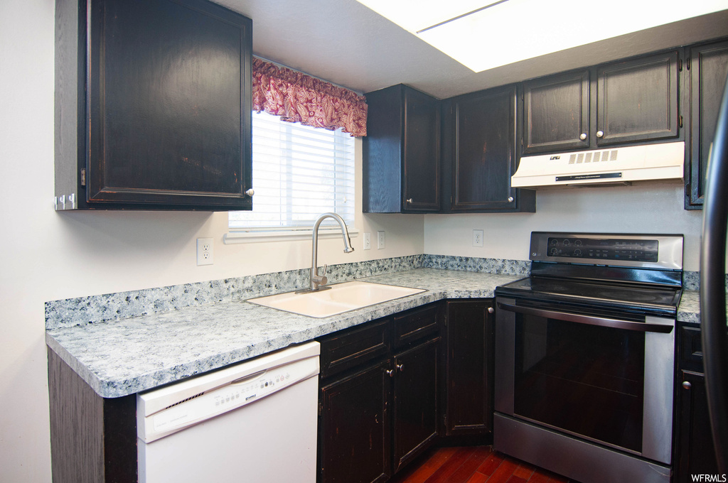 Kitchen featuring sink, dark hardwood flooring, stainless steel range with electric cooktop, and dishwasher