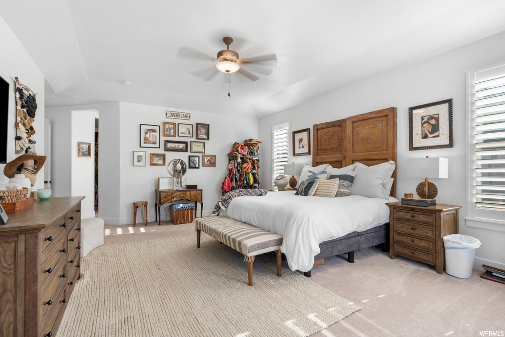 Bedroom featuring multiple windows, ceiling fan, and light colored carpet