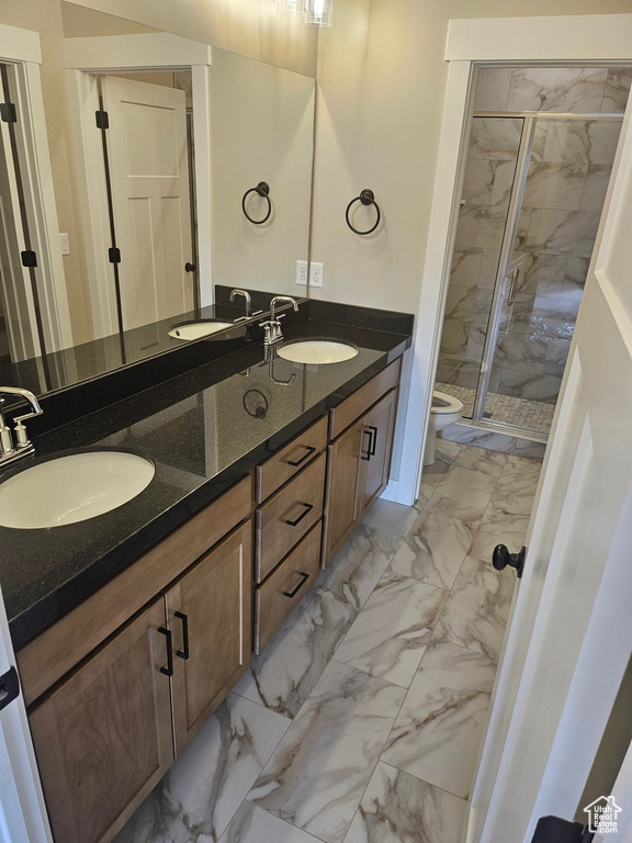 Bathroom with dual bowl vanity, tile flooring, walk in shower, and toilet