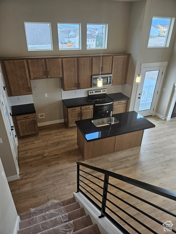 Kitchen featuring tasteful backsplash, hardwood / wood-style flooring, and appliances with stainless steel finishes