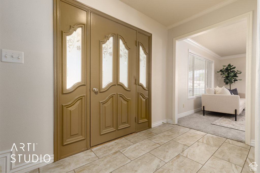 Entryway featuring crown molding and light tile flooring