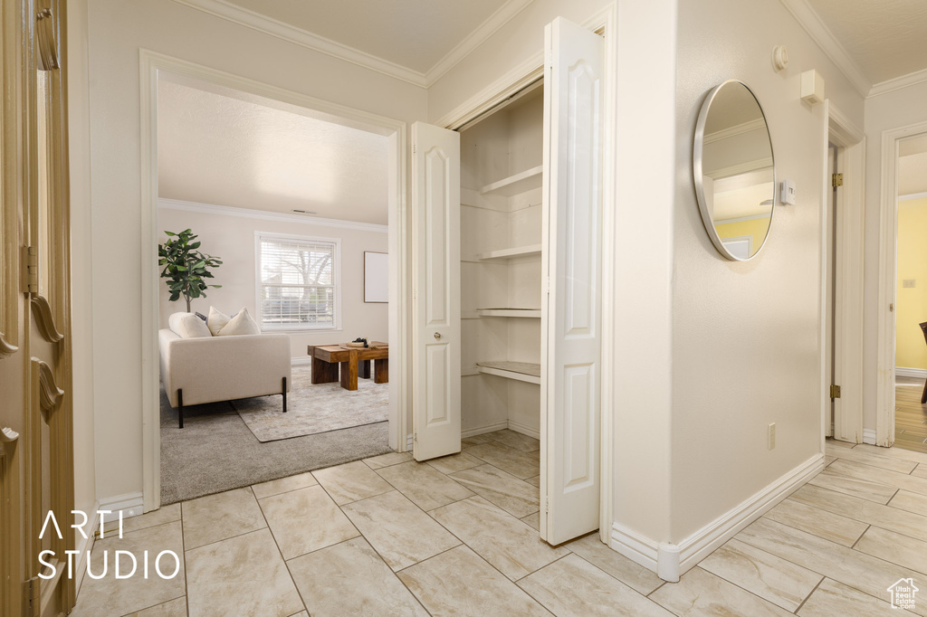 Interior space with crown molding and light tile floors