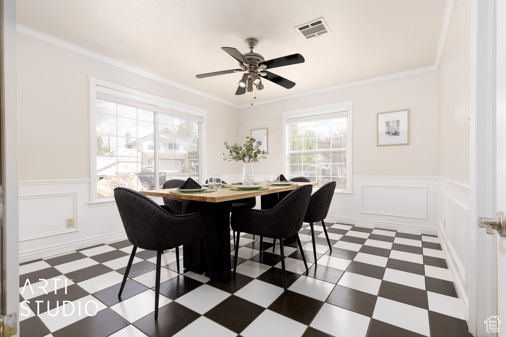 Dining room featuring crown molding, ceiling fan, and dark tile flooring