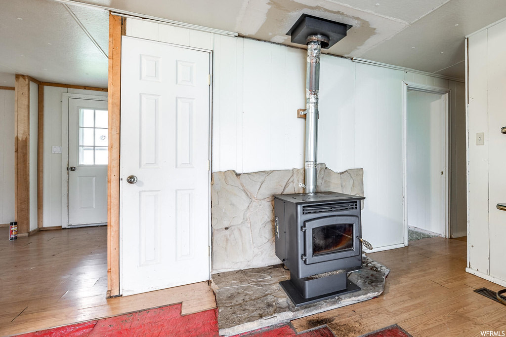 Interior space featuring a wood stove and light hardwood flooring