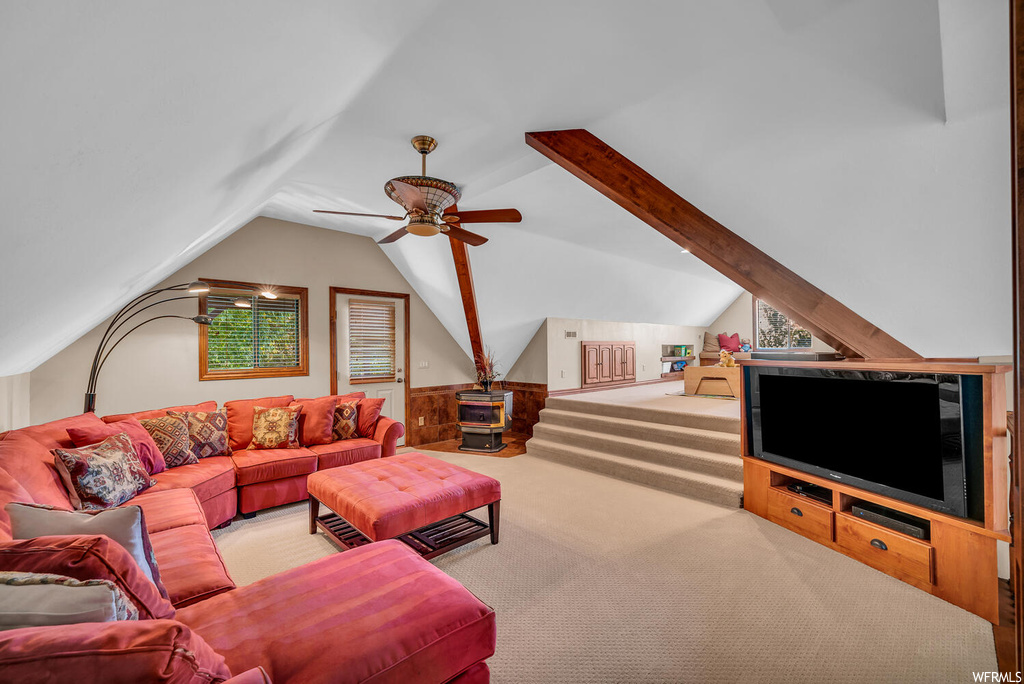 Living room featuring lofted ceiling, light carpet, and ceiling fan