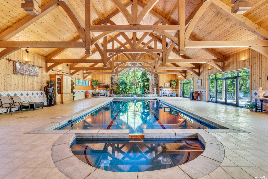 View of swimming pool featuring a patio area, exterior bar, and an indoor in ground hot tub
