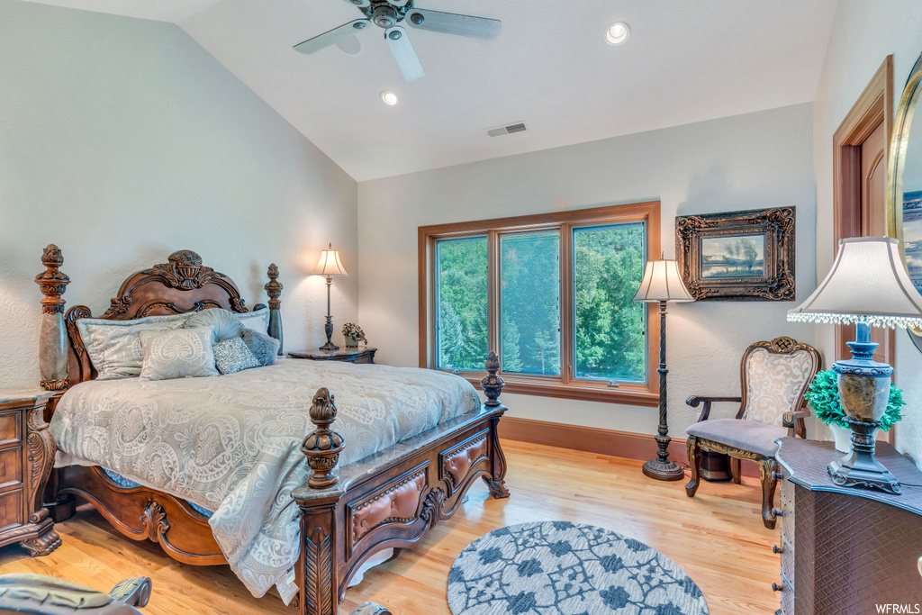 Bedroom featuring vaulted ceiling, light hardwood floors, and ceiling fan