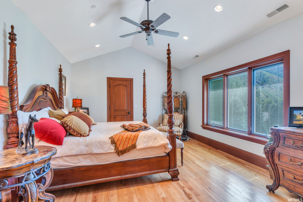 Bedroom with vaulted ceiling, ceiling fan, and light hardwood flooring