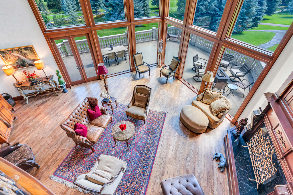 Living room featuring hardwood flooring, a towering ceiling, and french doors