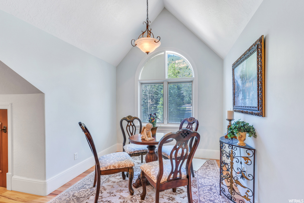 Dining area featuring vaulted ceiling and light hardwood floors