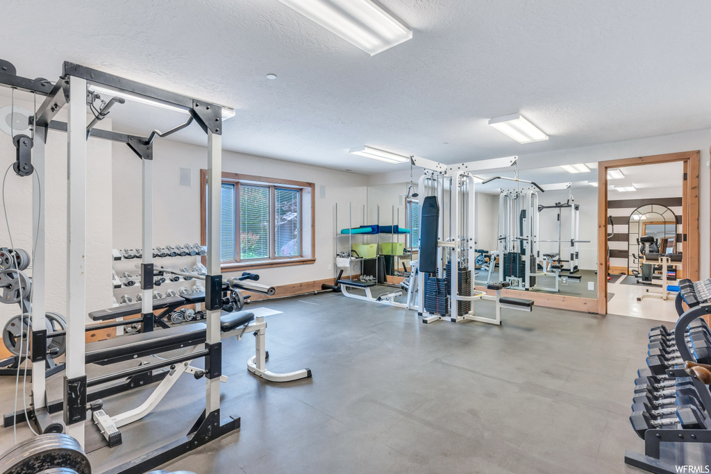 Gym featuring a textured ceiling and concrete flooring