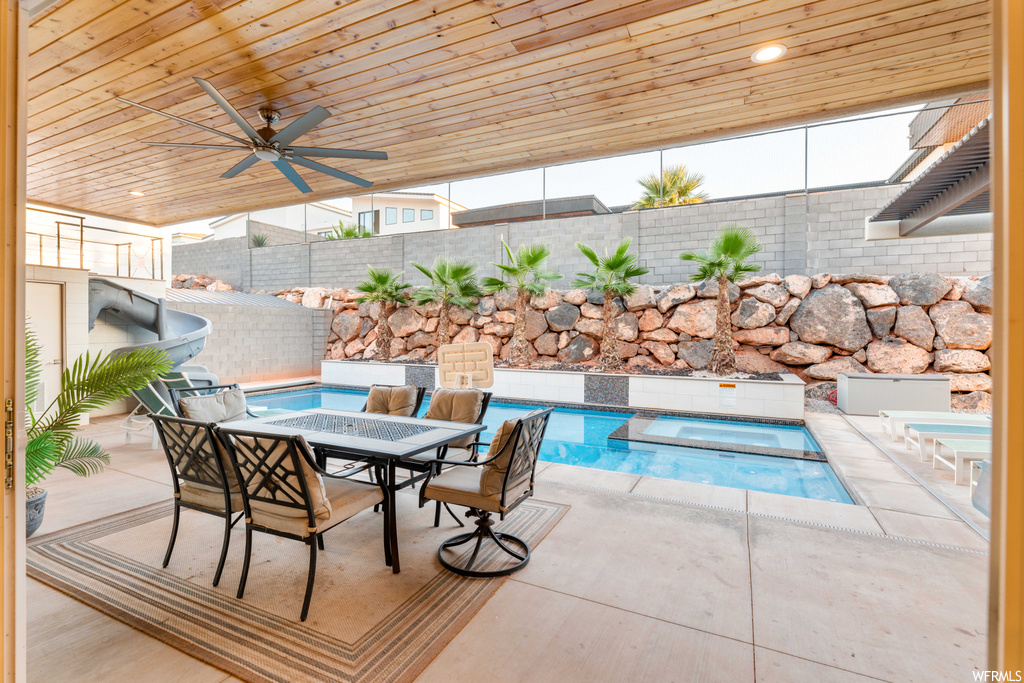 View of pool with an in ground hot tub, a patio area, and ceiling fan
