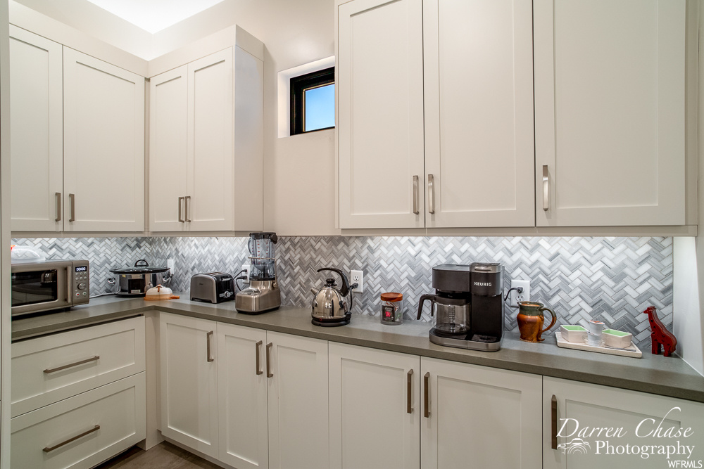 Kitchen with white cabinetry and backsplash