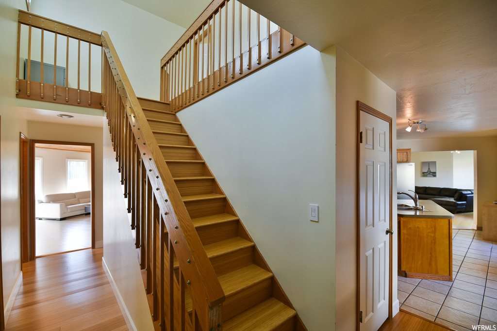 Stairs featuring sink and light hardwood flooring