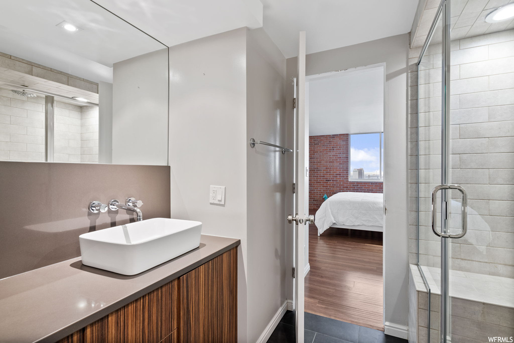 Bathroom featuring vanity, a shower with door, and hardwood / wood-style flooring