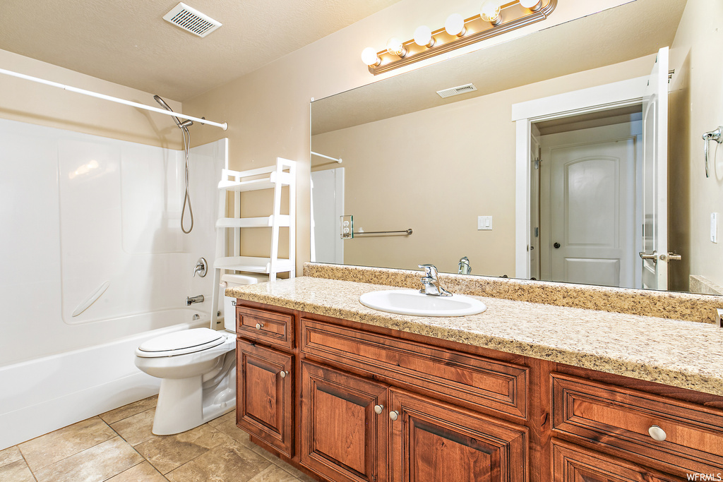 Full bathroom featuring shower / bathing tub combination, vanity, tile floors, and toilet