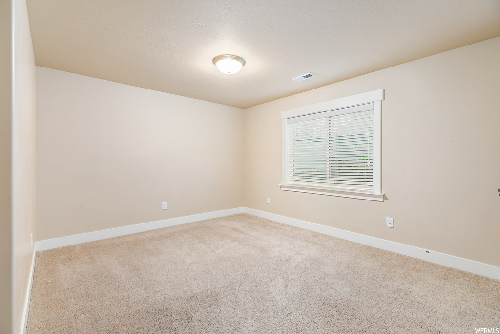Spare room with light colored carpet