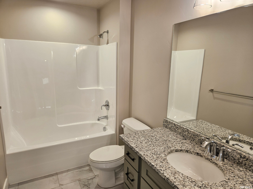 Full bathroom with toilet, tile flooring, tub / shower combination, and vanity