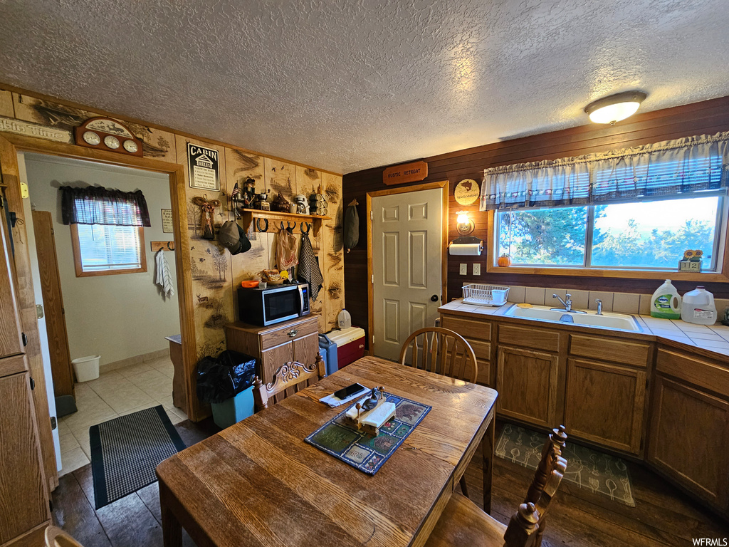 Kitchen with plenty of natural light, a textured ceiling, sink, and tile counters