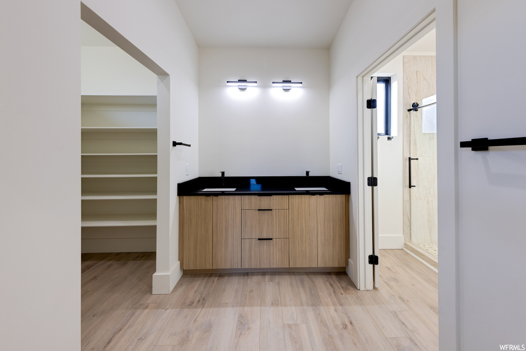 Bathroom with dual bowl vanity and hardwood floors
