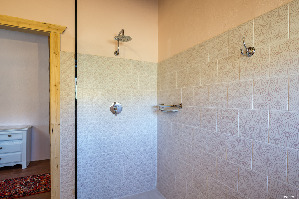 Bathroom with tiled shower and wood-type flooring